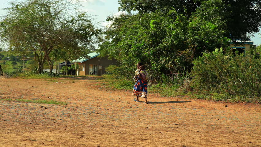 MOMBASSA, KENYA, AFRICA - CIRCA 2011: A girl carries a little baby in a village