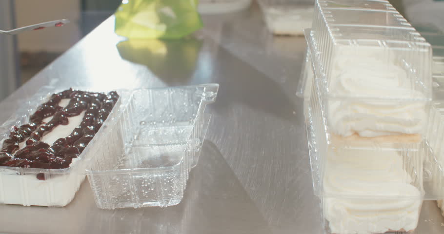 Baker spreading Blueberry jam over a cheese cake