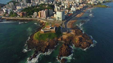 Aerial view of Salvador da Bahia, Brazil, tilt up shot showing historic Farol da Barra lighthouse and Salvador cityscape. 