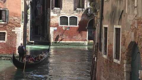 VENICE, ITALY -- SEPTEMBER 2014: Gondolier steering through canal in Venice in Venice, Italy.ULTRA HD 4K,real time