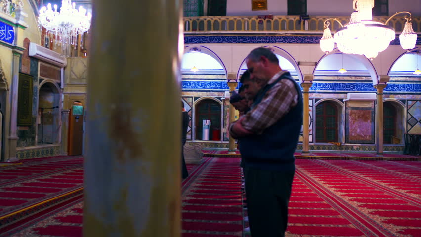 ISRAEL - FEB 2011: Dolly shot past a pillar revealing men at prayer in a mosque