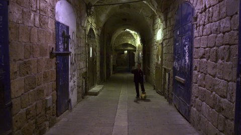 ISRAEL - FEB 2011: Dolly shot of a boy Kicking a soccer ball in an arched alley at night in the city of Akko, Israel.  Shot with the Red One digital camera at 4k (4096 x 2304) resolution.  02/19/2011.