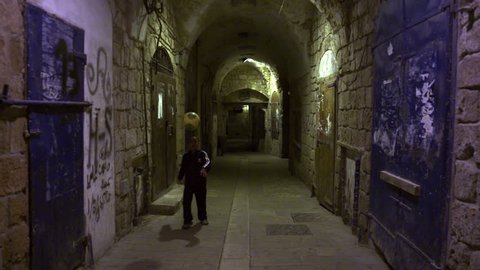 ISRAEL - FEB 2011: Dolly shot of a boy kicking a soccer ball in an arched alley at night in Akko Israel.  Shot with the Red One digital camera at 4k (4096 x 2304) resolution.  02/19/2011.