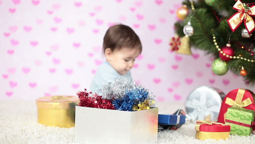 Happy boy sitting on the floor among the gifts