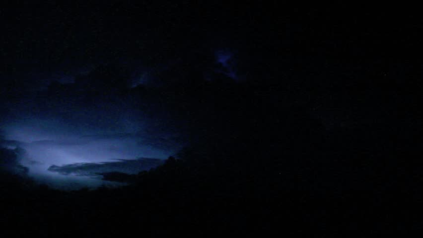 Light shining, storm, thunderbolt and dark clouds in the night sky.