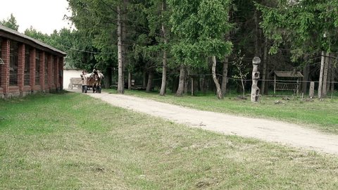 DUDUTKI - 24 JUNE 2014: Tourists ride on a wooden cart drawn. Museum complex of ancient crafts and technologies on 24 JUNE 2014 in DUDUTKI, BELARUS.
