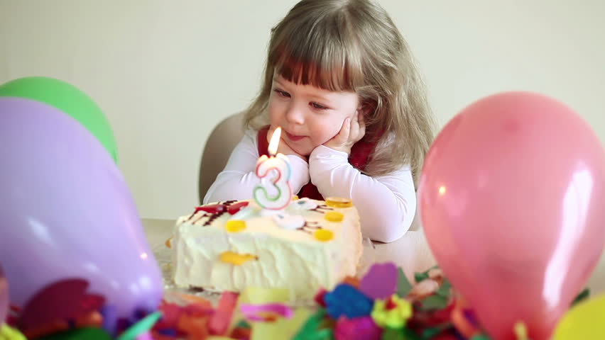 Baby girl blows out the candle on the cake