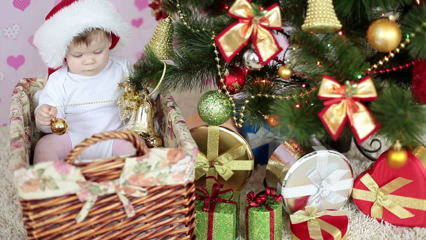 Hungry child is near a Christmas tree and gifts