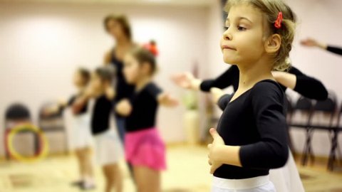 Girls learn how to dance with ballet teacher in recreation center