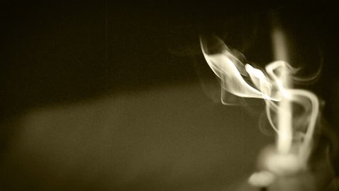 Cigarette/tobacco pipe swirls in midair in tha lamp's light