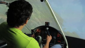 Young man navigating flight simulator, maneuvering steering wheel, video game