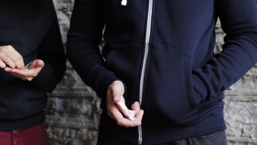 drug trafficking, crime, addiction and sale concept - addict buying dose from drug dealer on street