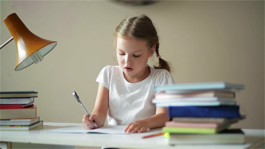 Schoolgirl doing homework and preparing for exams, cute children learning her lessons, children