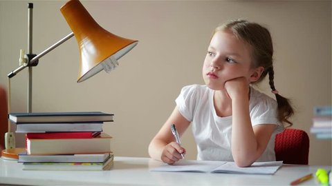 little schoolgirl learns lessons, thoughtful child doing homework, back to school