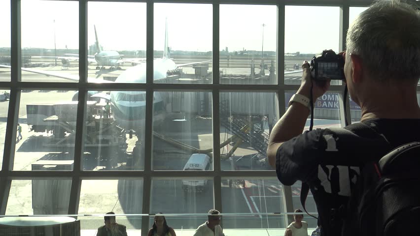 , Thailand-09 April, 2016: 4k, Asian Photographer takes pictures with DSLR camera of the plane in the Suvarnabhumi airport at Thailand. Travellers walking inside airport terminal in Bangkok-Dan | Shutterstock HD Video #17328925