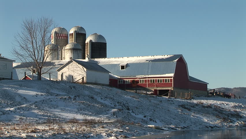 Zoom-out from barn and silo to reveal house and river