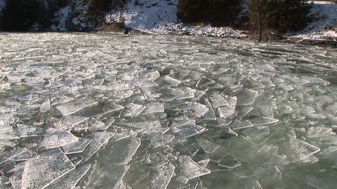 Overlapping shards of ice float on frigid lake