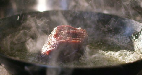 A young expert cook a beef fillet in the pan in the Italian tradition of the italian meat fillet gourmet beef