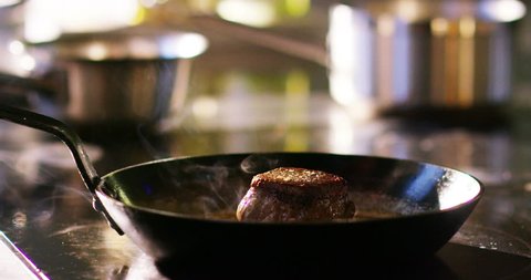 A young expert cook a beef fillet in the pan in the Italian tradition of the italian meat fillet gourmet beef