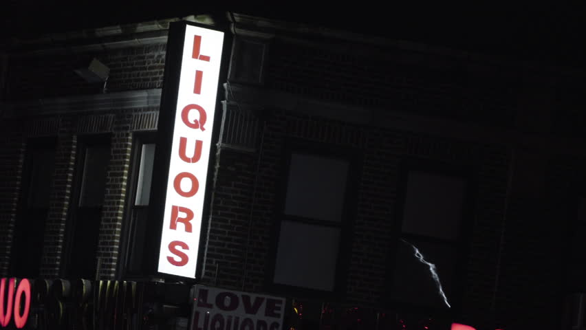 Establishing shot of a Liquor store exterior at night. New York - May 1, 2016