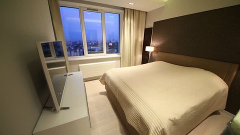 Bedroom with double bed and TV, overlooking the city at night