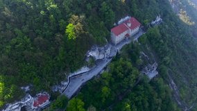 Monastery aerial view. Video monastery quadrocopters. Monastery on a cliff near the river in the forest