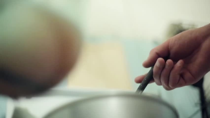 Hands got out inedible mass with music elements from saucepan, put it in bank. Art house cooking