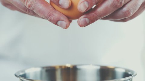 chef cracking an egg in a bowl