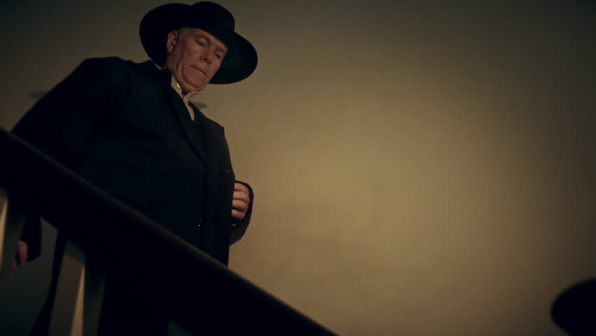 slow motion cowboy walking down stairs and pulls pistol