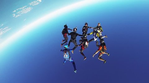 Professional skydivers parachuting above coast of Dubai. Formation. Dance. Sunny day.