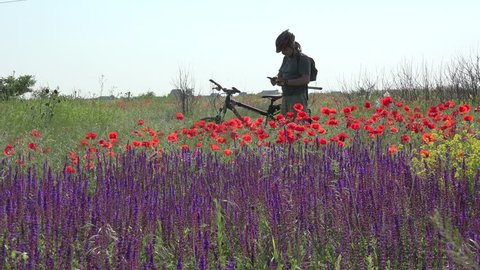 Tourist on bicycle photographed on mobile phone fantastic nature meadow