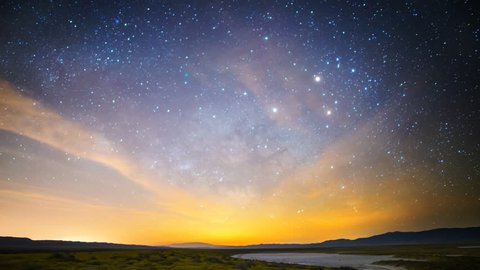 Astrophotography time lapse with motion of Milky Way galaxy & moon rising over Desert Gold wildflower super bloom 2016 in Carrizo Plain National Monument, California -Tilt Down-