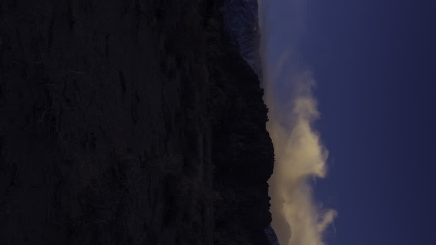 3 axis motion controlled time lapse with dolly up left, tilt up & pan right motion of storm clouds over Sierra Nevada mountains in California -Vertical Shot-