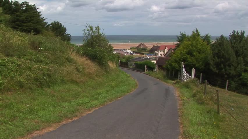 View of steep road that American forces used in WWII to reach cliff top from beach below with the village of Vierville-sur-Mer in background at Omaha Beach, Normandy France