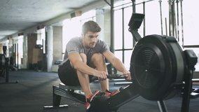 Handsome man doing exercise on fitness machine in gym
