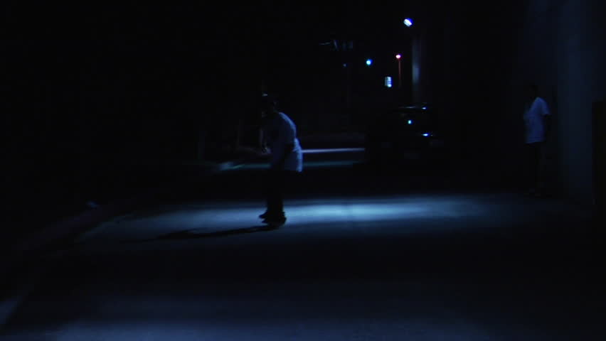 Skater 360flips out of the darkness and into a pool of light in an otherwise dark alley as another nose manuals. Shot at 60 fps. | Shutterstock HD Video #17402884