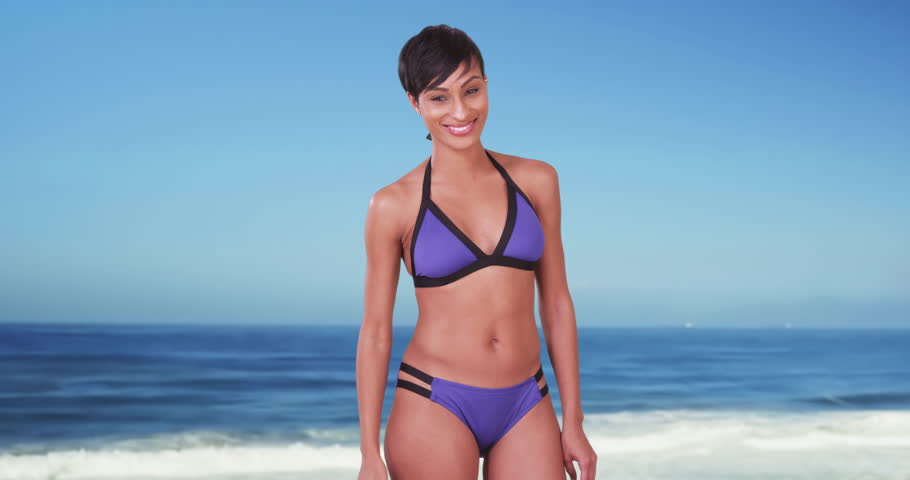 Black women in bikinis at beach Sexy Black Woman In Swimsuit At Beach African American Millennial In Her 20s Wearing Swim Suit With Ocean And Smiling