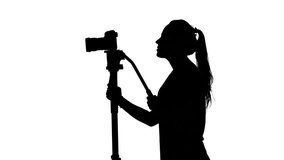 Shooting video or film. Operator at the studio. White. Silhouette