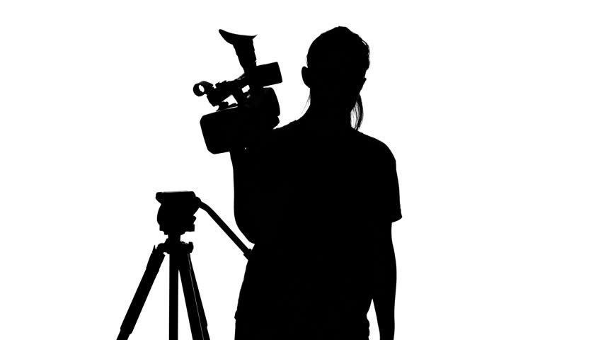 Girl is hooks the camera to the tripod. White. Silhouette