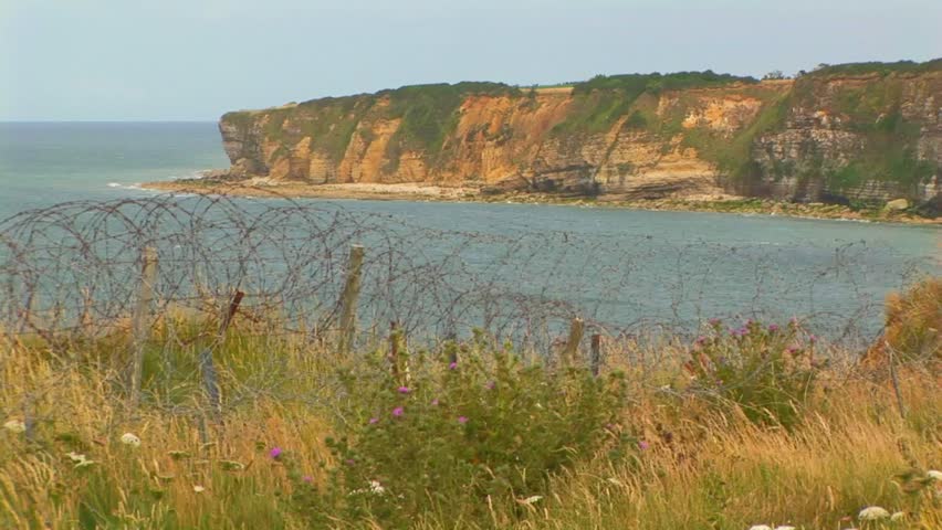 View of Pointe du Hoc cliffs with English Channel, part of landing site of allied forces during invasion June 6th 1944 with barbed wires in foreground. Normandy France