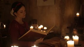Medieval woman reading mysterious book in ancient castle interior in 4K UHD video.