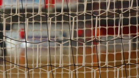 Futsal background with goalie net and players out of focus