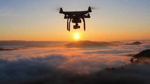 drone flying over cloud in morning, in a aerial shot,  drone moving in to the sun.