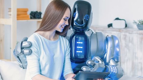 Positive woman sitting on the couch with modern robot