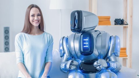Modern robot sitting on the couch with cheerful woman