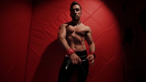 Brutal muscular man in the red room dancing