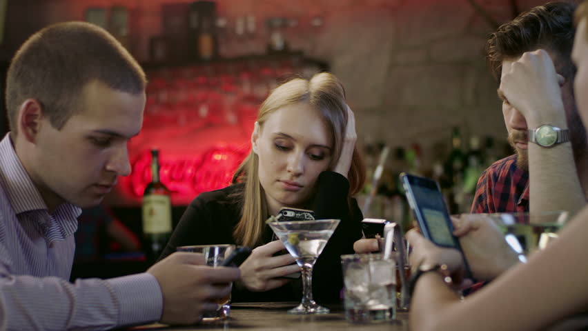 Company of young people is looking at their cellphones in the bar | Shutterstock HD Video #17445121