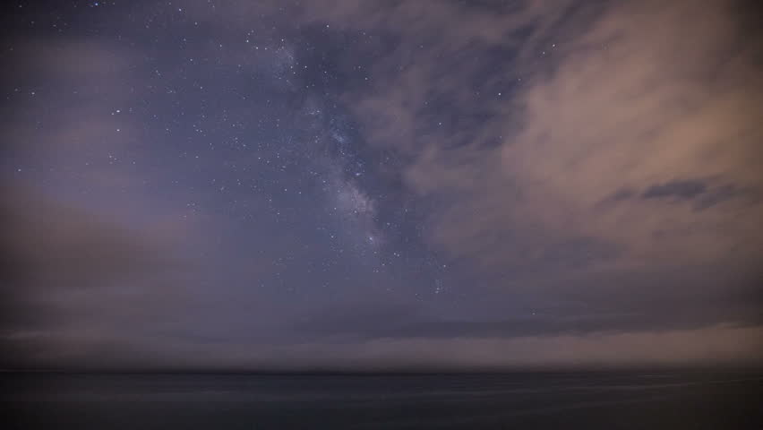 Timelapse sequence of a starry night with the Milky Way moving over the Pacific Ocean.