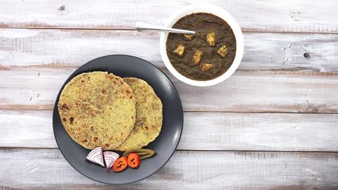 Flat lay of Gujarati flatbread Methi Thepla Indian cuisine served with traditional Punjabi Palak Paneer dish and Samosa.India food background and texture copy space