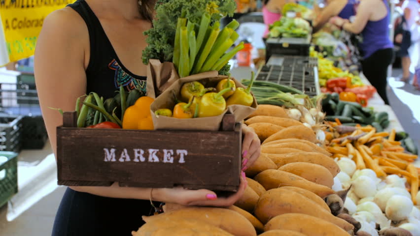 Young woman shopping at the local Farmers market.